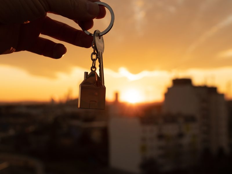 Llaves de un piso con la ciudad al atardecer al fondo