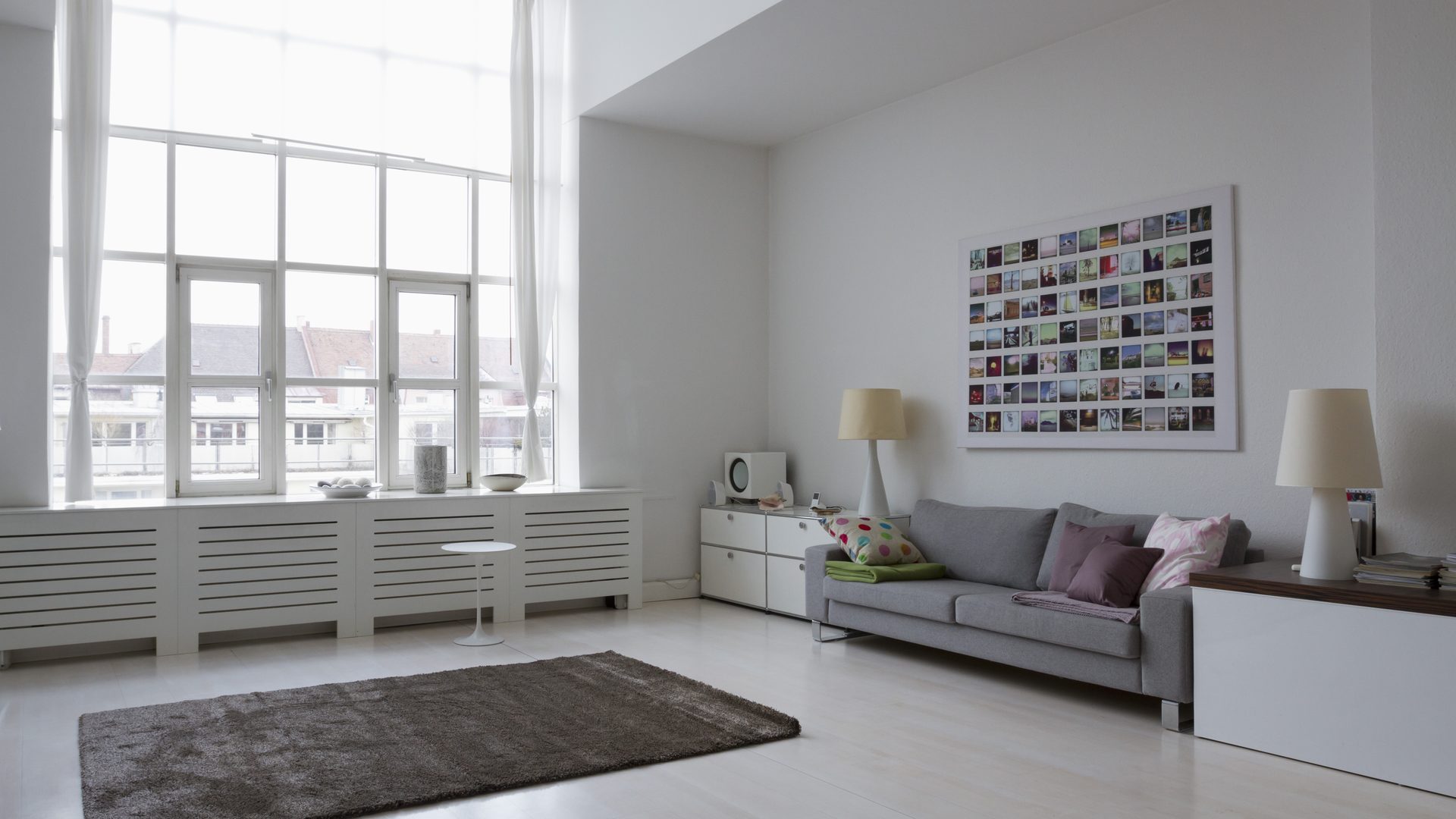 Salón con ventana grande y radiador, lo que mide el certificado energético de un piso en Zaragoza Certificado energético para alquilar un piso en Zaragoza: salón luminoso con ventana grande y radiador bajo la ventana