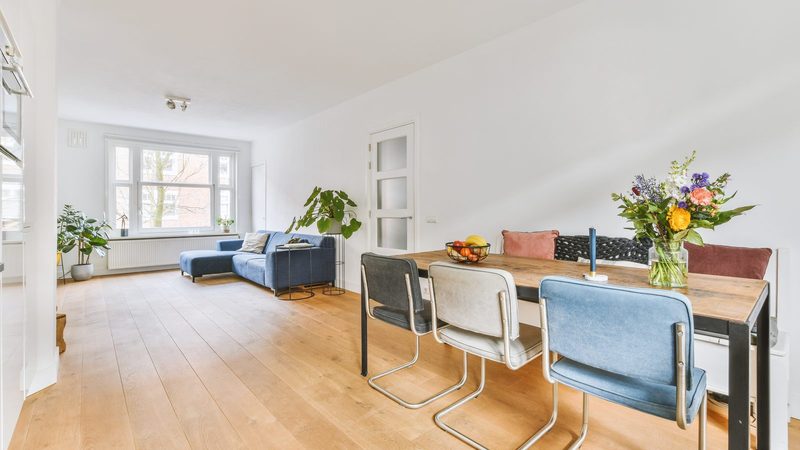 Fully managed letting service in Zaragoza: a bright living and dining room with a blue sofa, ready to let