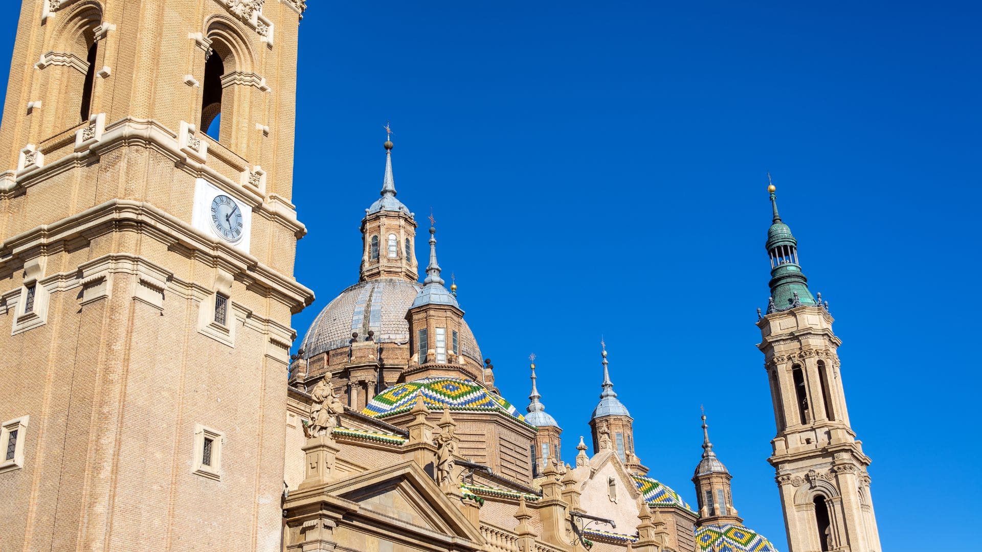 Propietario que quiere alquilar su piso en Zaragoza, con la Basílica del Pilar al atardecer